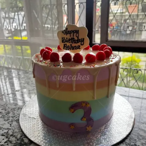 Rainbow colored birthday cake with cherry toppings